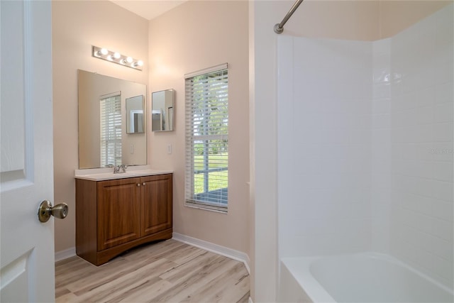 404 Central Mariners Dr, Edgewater, FL 32141 - bathroom featuring wood finished floors, vanity, baseboards, and shower / bath combination