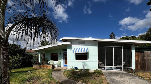 rear view of property with a sunroom and fence