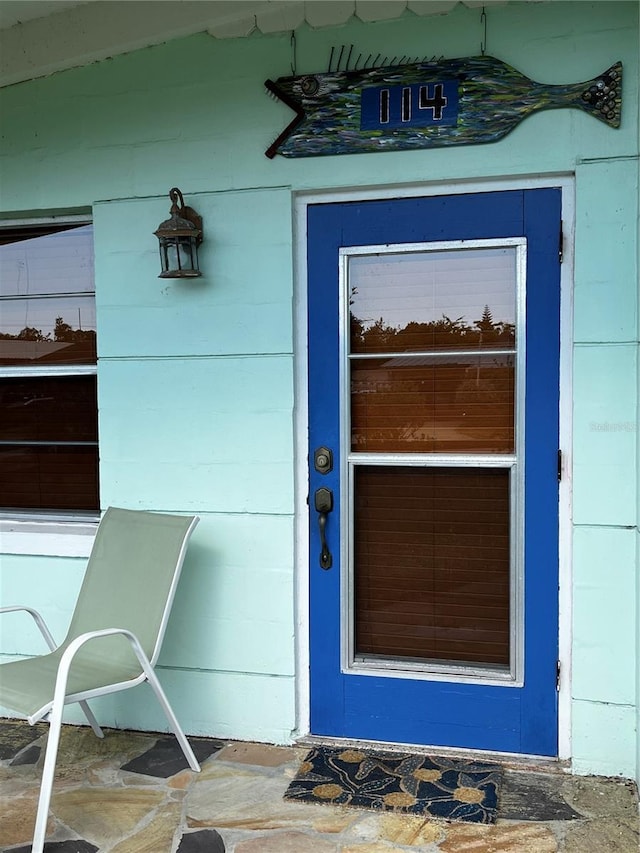 doorway to property featuring concrete block siding