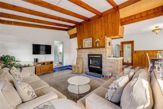 living area with wood walls, beamed ceiling, a fireplace, and a wainscoted wall