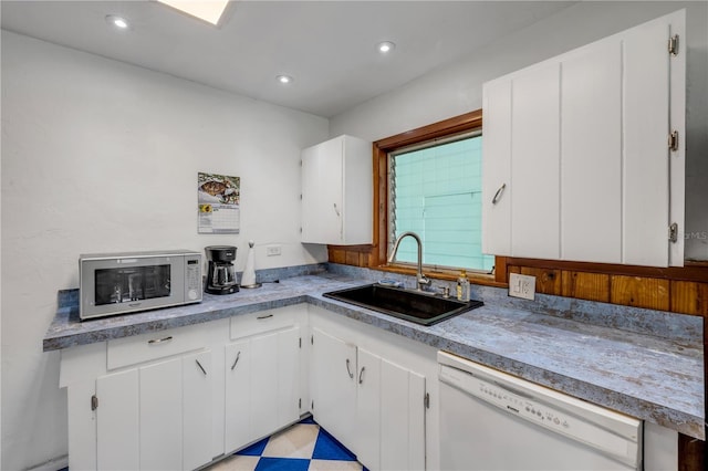 kitchen featuring white appliances, a sink, white cabinetry, and recessed lighting
