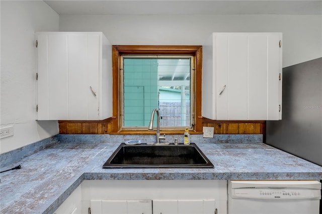 kitchen featuring a sink, white dishwasher, white cabinets, and light countertops