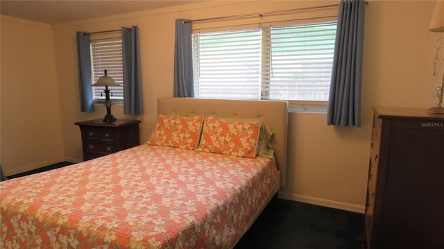 bedroom with baseboards and multiple windows