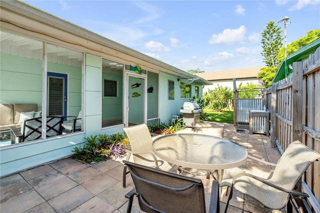 view of patio / terrace with grilling area, outdoor dining area, and fence