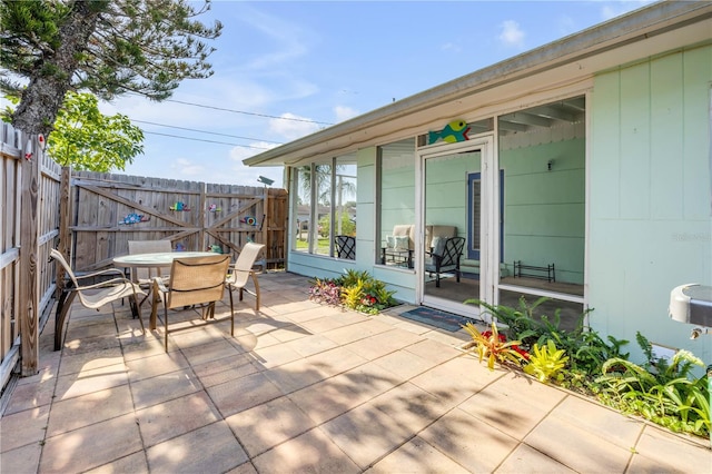 view of patio featuring outdoor dining area, fence, and a gate