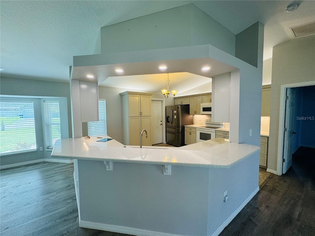 3303 Victory Palm Dr, Edgewater, FL 32141 - kitchen featuring white appliances, a peninsula, dark wood finished floors, lofted ceiling, and a breakfast bar area