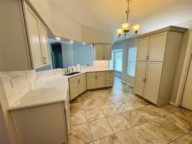 3303 Victory Palm Dr, Edgewater, FL 32141 - kitchen with a sink, a chandelier, decorative light fixtures, light stone counters, and backsplash