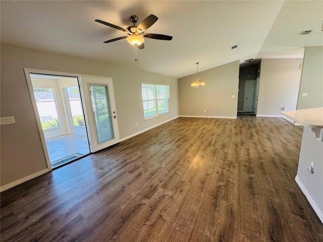 3303 Victory Palm Dr, Edgewater, FL 32141 - unfurnished living room with dark wood-type flooring, vaulted ceiling, ceiling fan, baseboards, and a chandelier