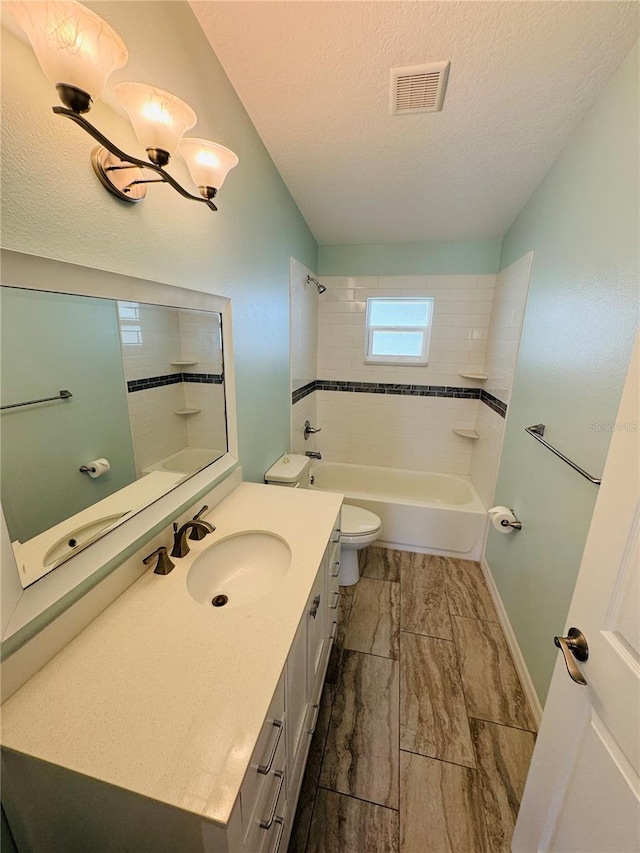 3303 Victory Palm Dr, Edgewater, FL 32141 - full bathroom featuring toilet, washtub / shower combination, vanity, a textured ceiling, and baseboards