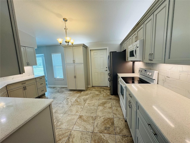 3303 Victory Palm Dr, Edgewater, FL 32141 - kitchen with white appliances, backsplash, a chandelier, hanging light fixtures, and light stone counters