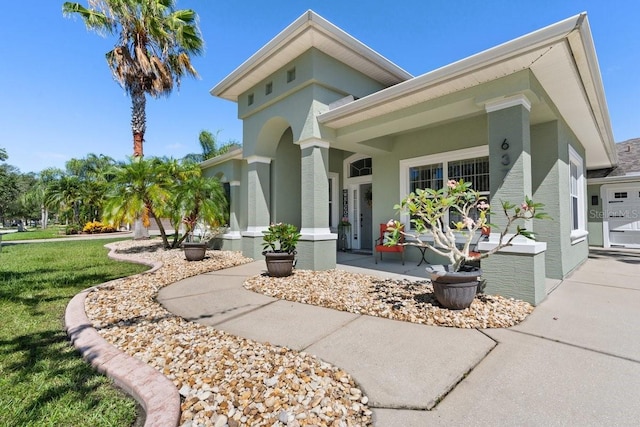 637 Marisol Dr, New Smyrna Beach, FL 32168 - view of front of home with a front lawn, stucco siding, and covered porch