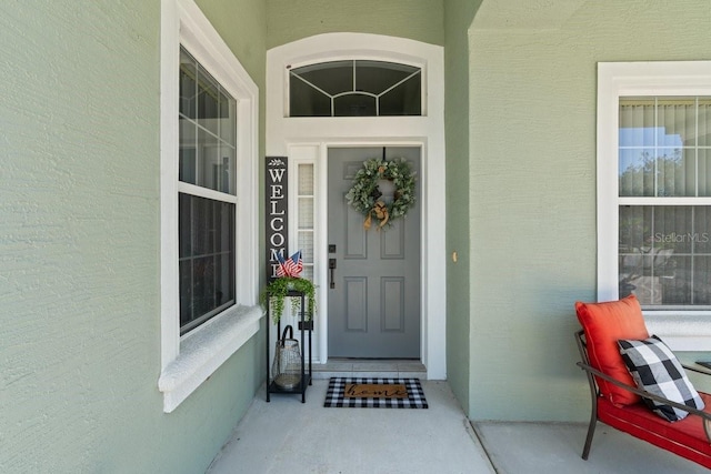 637 Marisol Dr, New Smyrna Beach, FL 32168 - property entrance with a porch and stucco siding