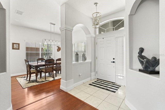 637 Marisol Dr, New Smyrna Beach, FL 32168 - tiled foyer featuring arched walkways, baseboards, a chandelier, and decorative columns