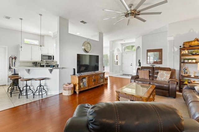 637 Marisol Dr, New Smyrna Beach, FL 32168 - living area with a ceiling fan, arched walkways, and light wood finished floors