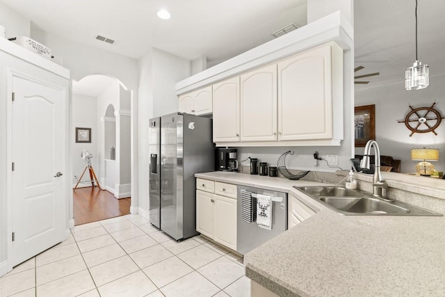 637 Marisol Dr, New Smyrna Beach, FL 32168 - kitchen with stainless steel appliances, a sink, arched walkways, light tile patterned floors, and pendant lighting