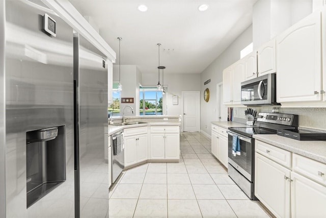637 Marisol Dr, New Smyrna Beach, FL 32168 - kitchen with appliances with stainless steel finishes, a sink, white cabinets, light countertops, and hanging light fixtures