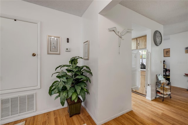 hall featuring light wood finished floors and baseboards