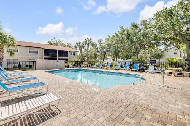 community pool featuring a patio area and fence
