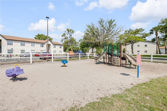 community playground featuring fence and a residential view