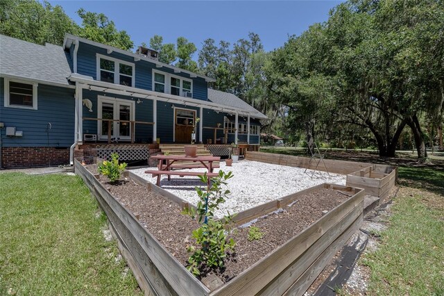 4580 Lake James Cir, Edgewater, FL 32141 - back of property featuring a vegetable garden, french doors, and a shingled roof