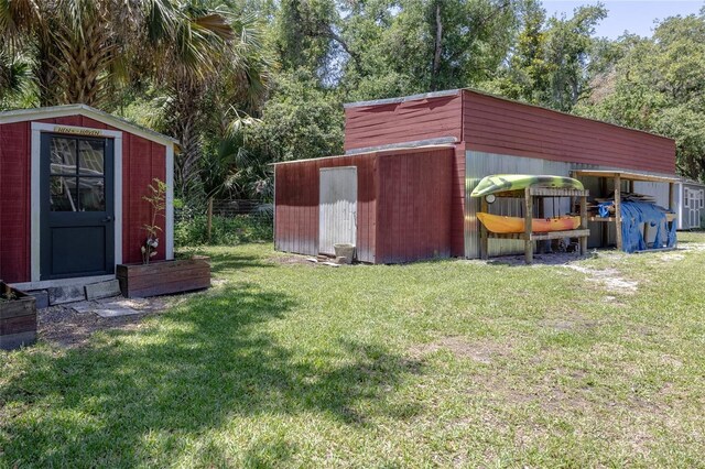 4580 Lake James Cir, Edgewater, FL 32141 - view of grassy yard with a storage unit and an outbuilding