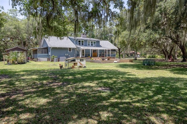 4580 Lake James Cir, Edgewater, FL 32141 - rear view of property with a sunroom, a wooden deck, a yard, and a chimney