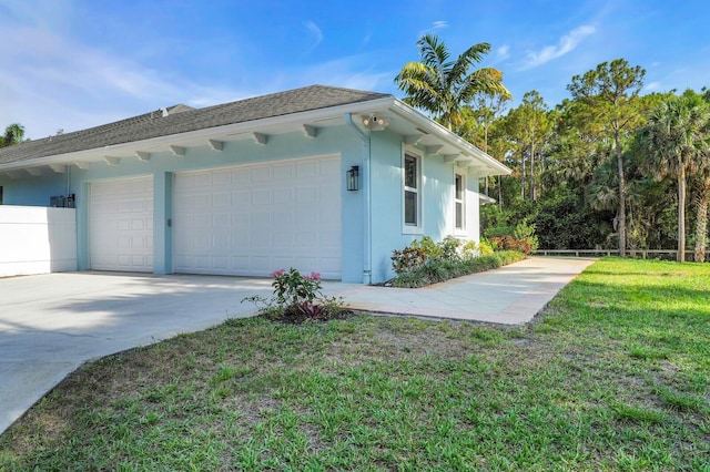 view of property exterior featuring a garage, stucco siding, a yard, concrete driveway, and roof with shingles