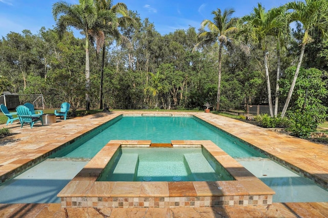 view of pool featuring a patio, a pool with connected hot tub, and fence