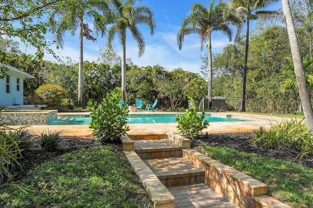 outdoor pool featuring an in-ground hot tub