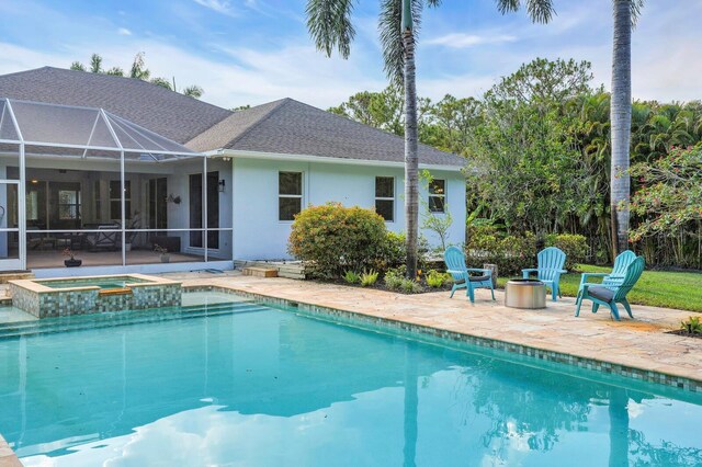 view of swimming pool with a patio, glass enclosure, and a pool with connected hot tub