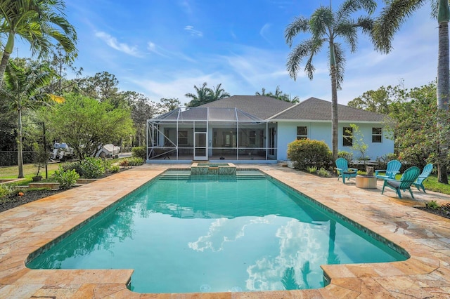 view of swimming pool featuring a patio, a lanai, a pool with connected hot tub, and an outdoor fire pit