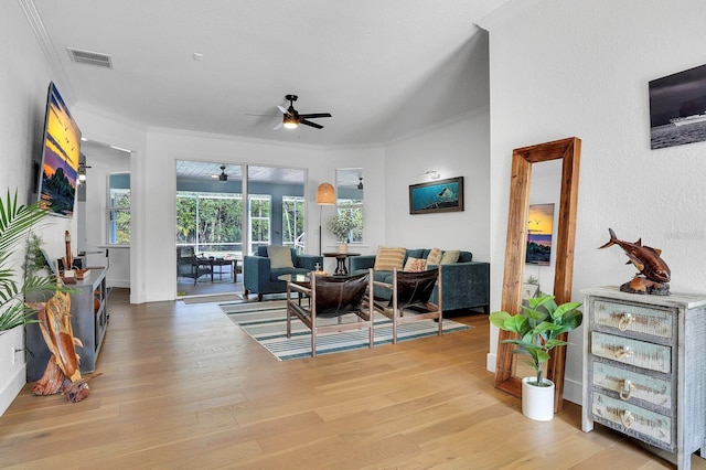 dining space featuring ceiling fan, crown molding, light wood-style flooring, and baseboards