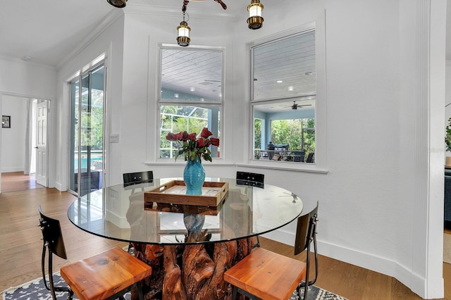 dining area with crown molding, wood finished floors, baseboards, and ceiling fan