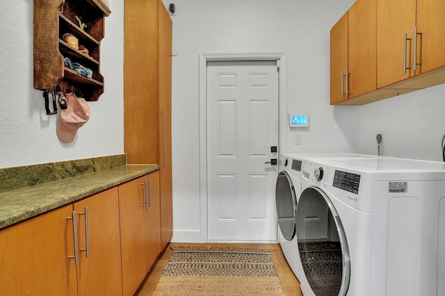 laundry area featuring cabinet space, separate washer and dryer, and light wood finished floors