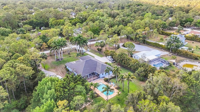 bird's eye view of a heavily wooded area and a pool area
