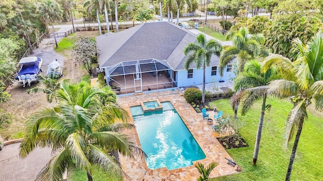 view of pool featuring a patio area, a pool with connected hot tub, and glass enclosure