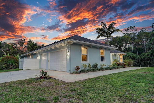 view of side of property with driveway, stucco siding, and a garage