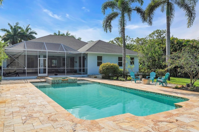 view of swimming pool featuring a patio area, glass enclosure, a pool with connected hot tub, and an outdoor fire pit