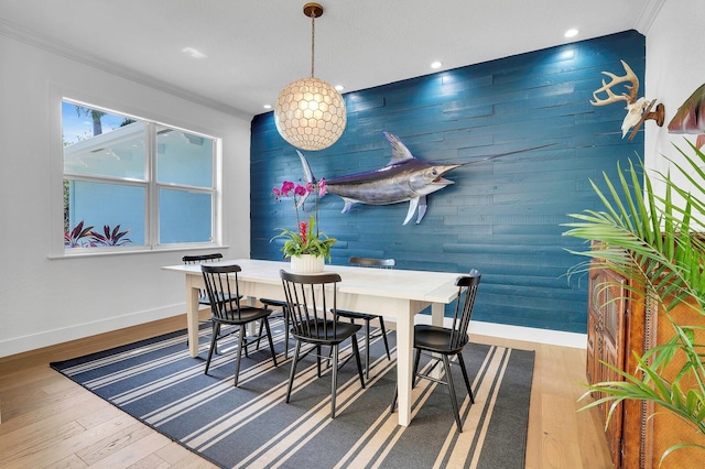 dining area with crown molding, baseboards, wood finished floors, wooden walls, and recessed lighting