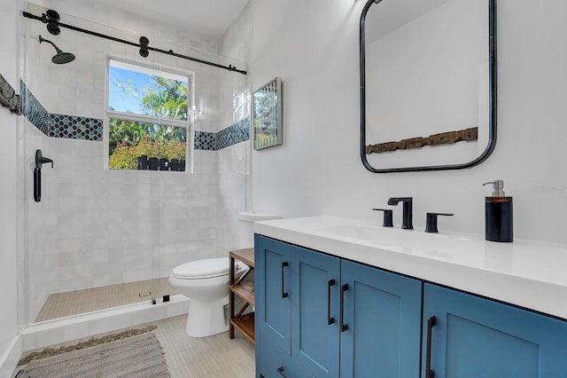 bathroom with a stall shower, vanity, toilet, and tile patterned flooring