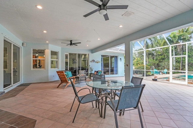 view of patio / terrace with a ceiling fan, an outdoor pool, glass enclosure, and outdoor dining space