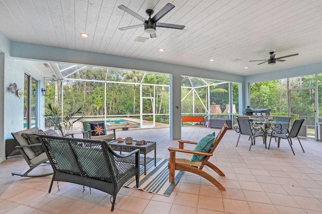 view of patio with a ceiling fan, a hot tub, and glass enclosure