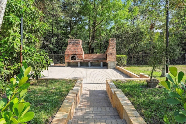 view of yard with an outdoor brick fireplace and fence