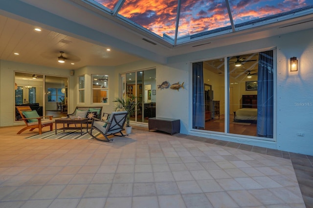 view of patio / terrace with ceiling fan, glass enclosure, and an outdoor living space
