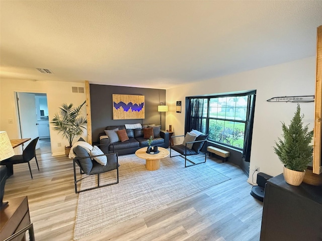 208 Wellington Dr, Daytona Beach, FL 32119 - living room with light wood-style flooring, baseboards, and a textured ceiling