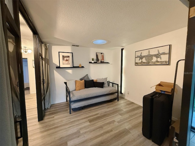 208 Wellington Dr, Daytona Beach, FL 32119 - bedroom with a textured ceiling, light wood-type flooring, and baseboards