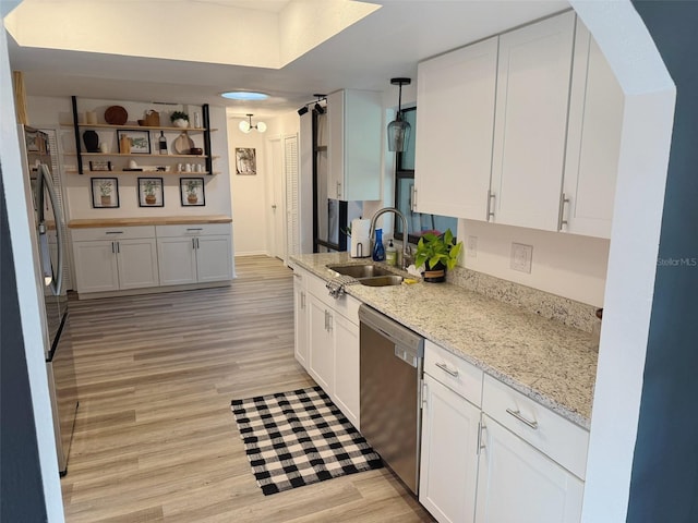 208 Wellington Dr, Daytona Beach, FL 32119 - kitchen with stainless steel appliances, a sink, white cabinets, and light wood-style flooring
