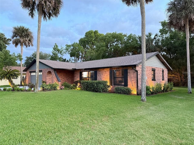 208 Wellington Dr, Daytona Beach, FL 32119 - view of front of house with brick siding, a garage, a front yard, and roof with shingles