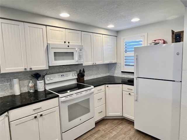 2100 N Peninsula Ave Unit 2160, New Smyrna Beach, FL 32169 - kitchen with white appliances, wood finished floors, recessed lighting, decorative backsplash, and a textured ceiling