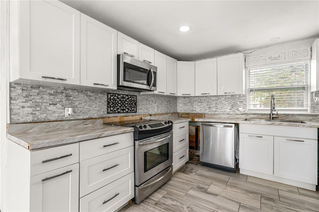 2576 Sunset Dr, New Smyrna Beach, FL 32168 - kitchen featuring stainless steel appliances, a sink, white cabinets, decorative backsplash, and recessed lighting